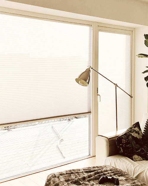 Plisségardiner monterade för solskydd på fönster och balkongdörrar